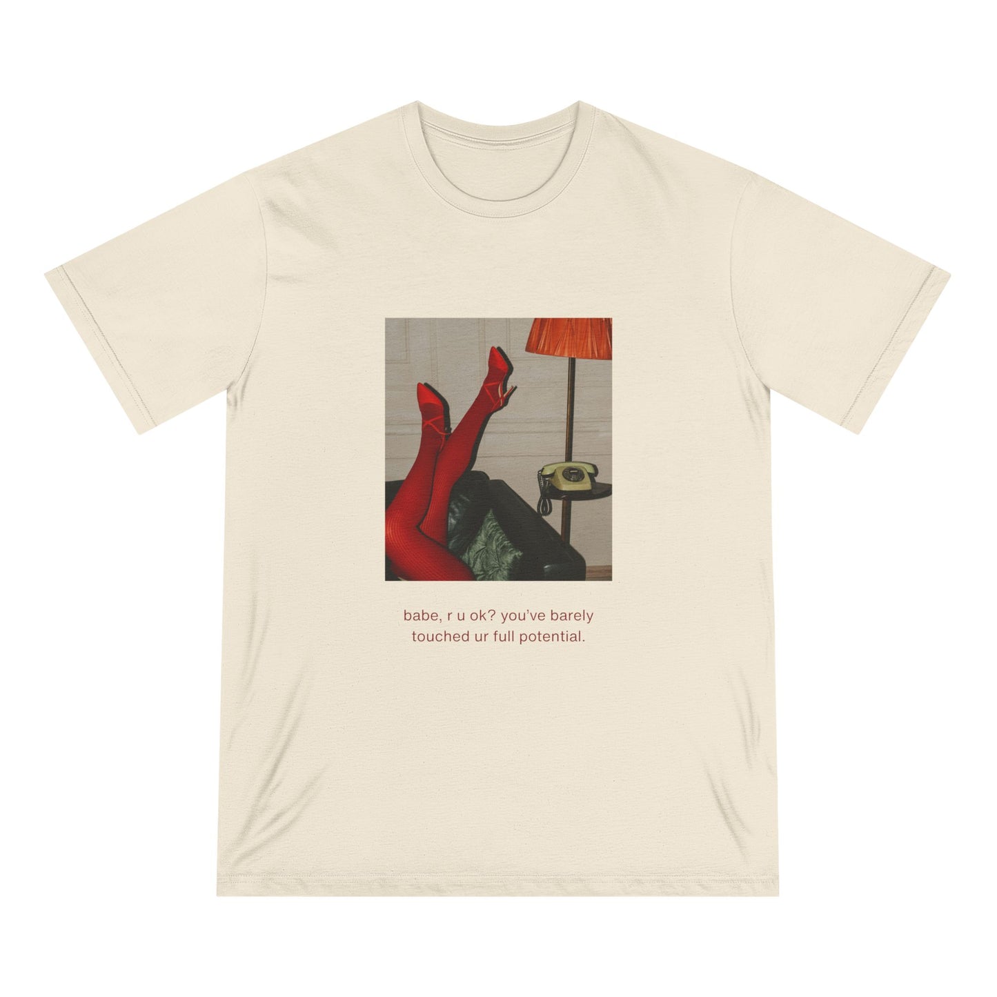 Front view of natural organic cotton t-shirt featuring vintage photo of crossed red legs, orange lamp, and green rotary phone with text that reads “babe, r u ok? you’ve barely touched ur full potential.” from Office Off-Duty.
