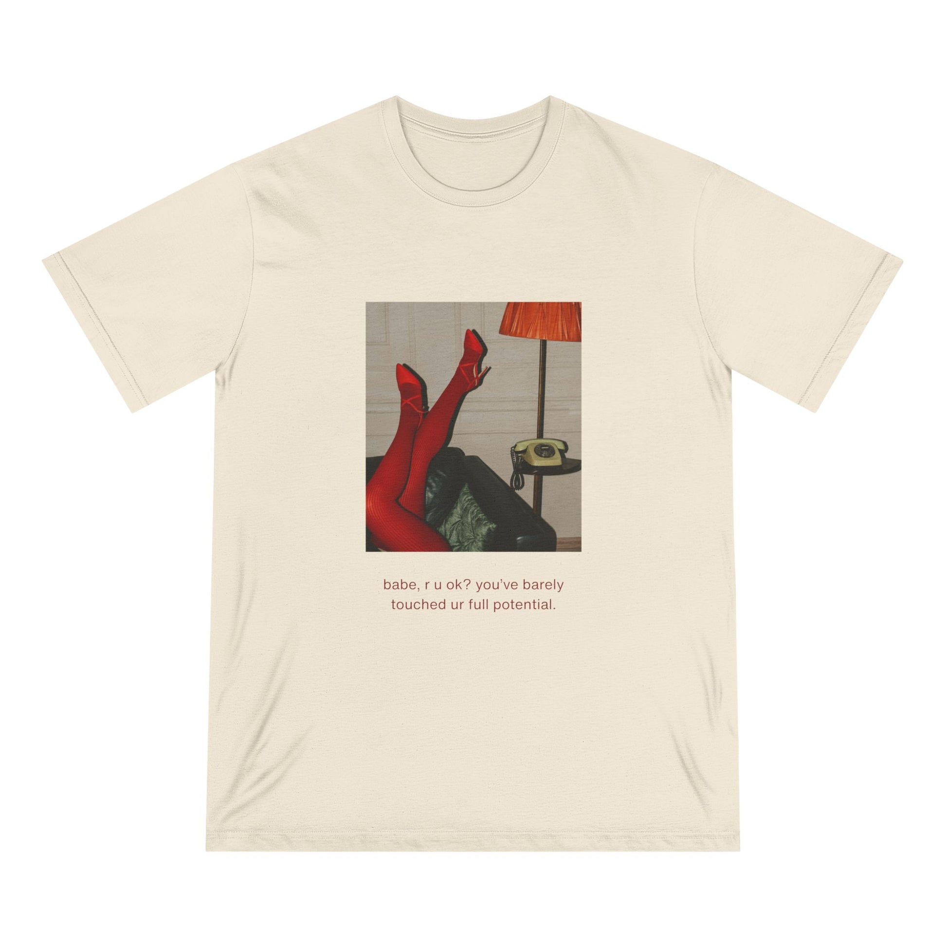 Front view of natural organic cotton t-shirt featuring vintage photo of crossed red legs, orange lamp, and green rotary phone with text that reads “babe, r u ok? you’ve barely touched ur full potential.” from Office Off-Duty.