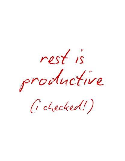 Close-up of the red handwritten text design reading “rest is productive (I checked!)” featured on the Office Off-Duty organic cotton tee. Minimalist typography meets soft, mindful energy.